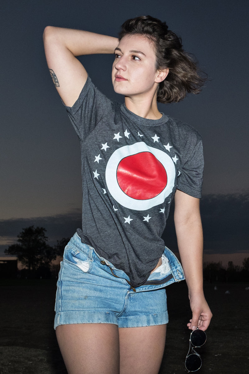 The Union O Rock Tee By Mysterioso Rock Art Model Haley is wearing a Dark Heather Gray t-shirt with the printed design of an outer white circle inside a ring of 17 stars and a center red circle as shown on the ohio state flag photo by Chip Willis