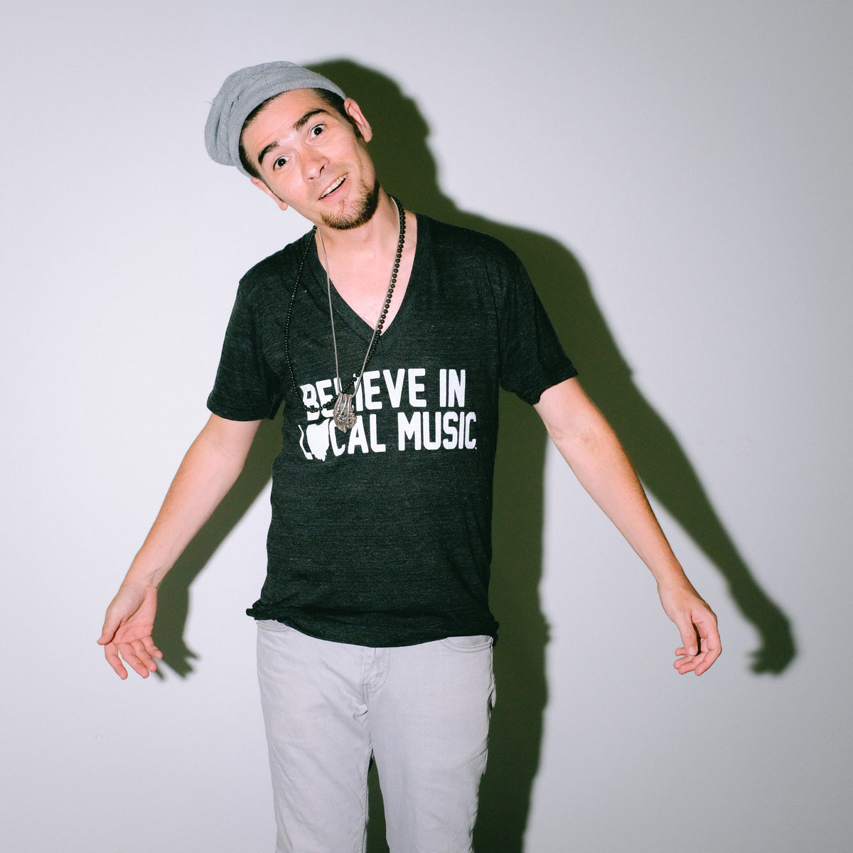 Believe In Local Music in White Print on a Black V-Neck T-Shirt as worn by model Joey Gurwin Mysterioso Rock Art