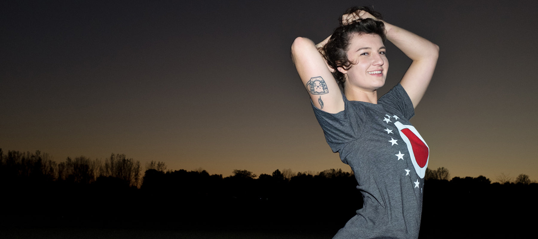 The Union O Rock Tee By Mysterioso Rock Art Model Haley is wearing a Dark Heather Gray t-shirt with the printed design of an outer white circle inside a ring of 17 stars and a center red circle as shown on the ohio state flag photo by Chip Willis